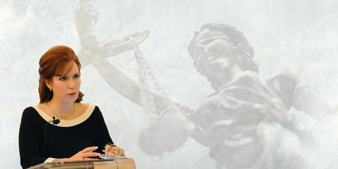Diana Santa Maria stands at a podium, confidently delivering a speech to an engaged audience.